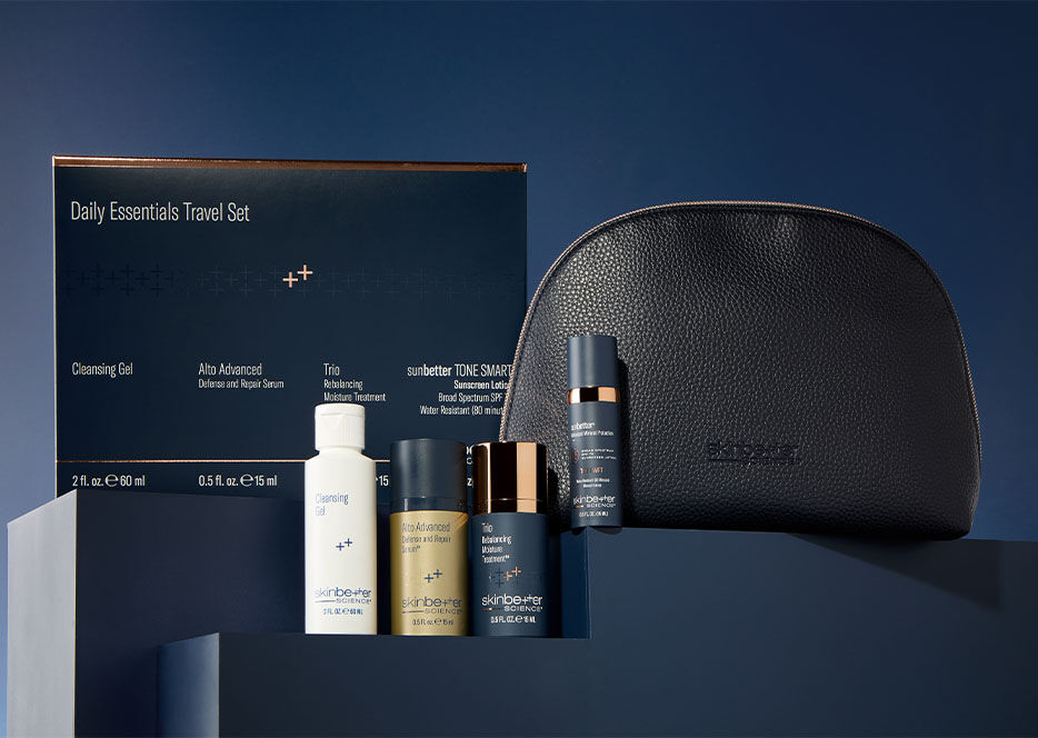skinbetter daily essentials travel kit including deluxe size products, a travel pouch, displayed on a shelf with dark navy background