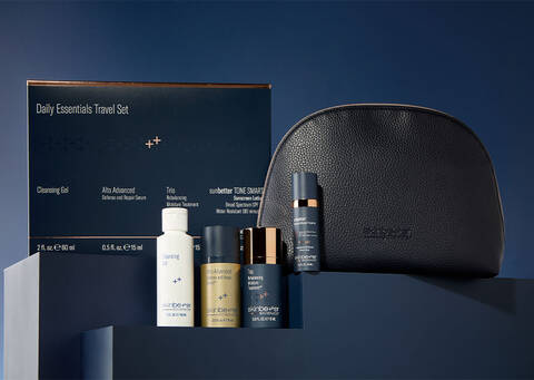 skinbetter daily essentials travel kit including deluxe size products, a travel pouch, displayed on a shelf with dark navy background